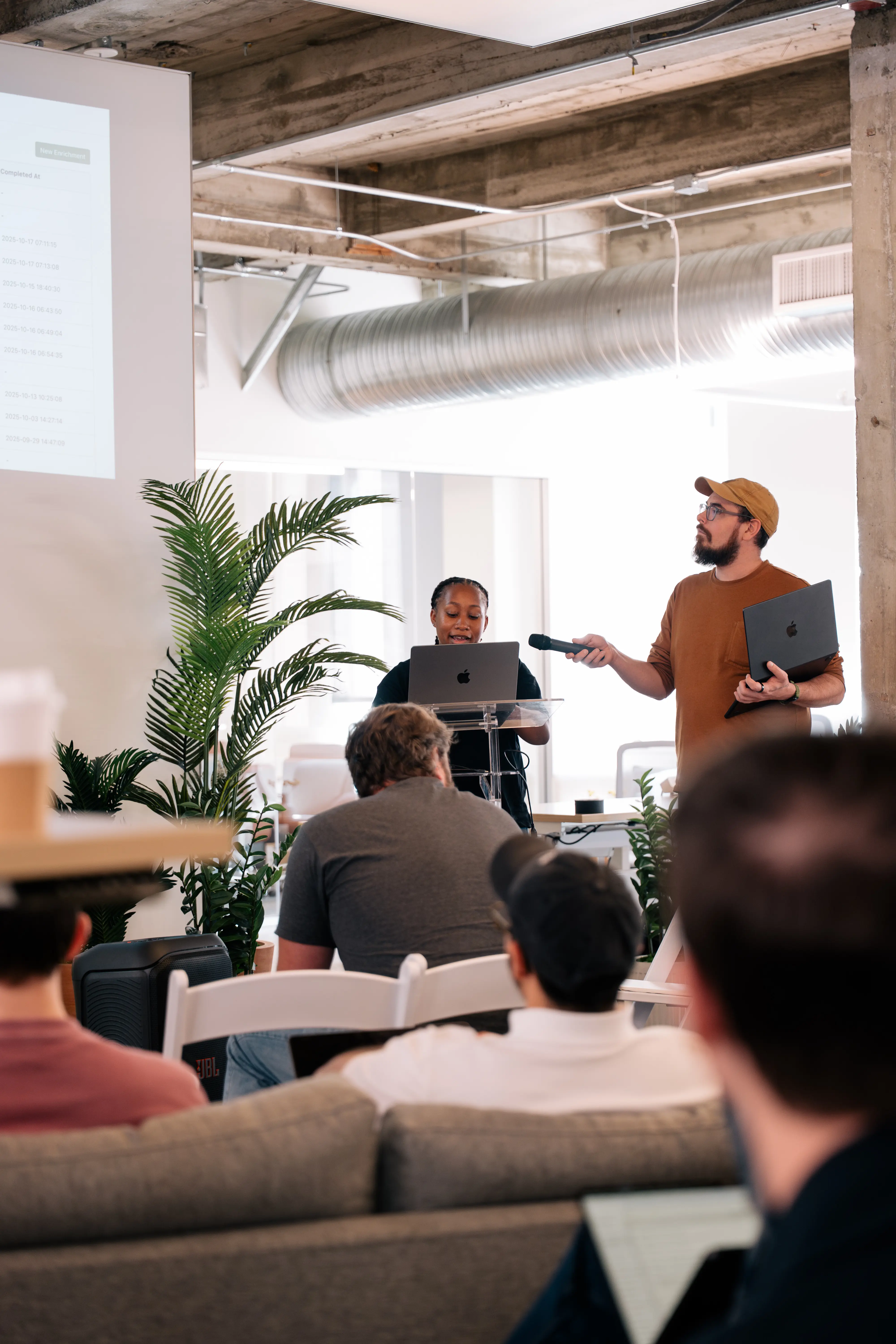 Zack presenting during an internal training, holding a mic
